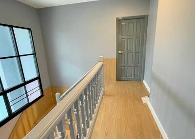 A bright hallway with wooden floor and a window