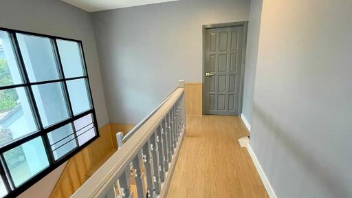 A bright hallway with wooden floor and a window