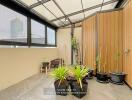 Spacious balcony with plants and seating under a transparent roof