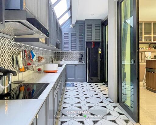 Modern kitchen with geometric tile flooring, grey cabinets, and ample natural light