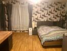 Well-furnished bedroom with a double bed and wooden flooring