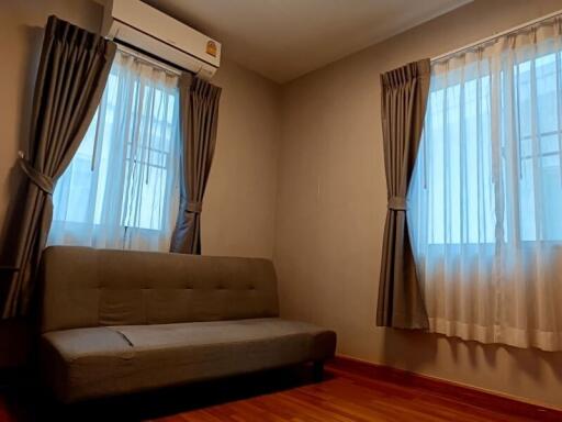 Living room with a sofa and two windows with curtains