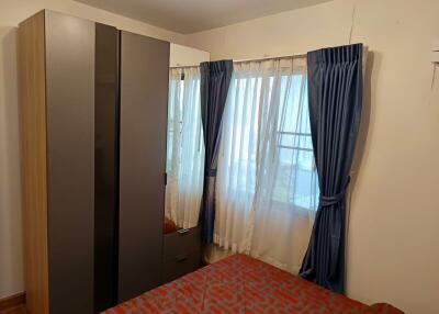 Bedroom with wardrobe and window with blue curtains