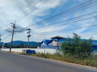 Exterior view of a building with blue roofs along a road