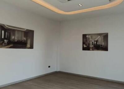 Empty living room with ceiling air conditioner and framed photos on wall