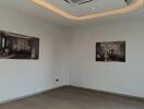 Empty living room with ceiling air conditioner and framed photos on wall