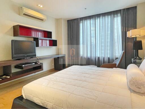 Modern bedroom with a TV, shelves, air conditioner, and double bed