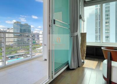 Balcony view towards high-rise buildings with glass door and curtains