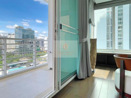 Balcony view towards high-rise buildings with glass door and curtains