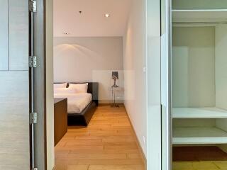 Bedroom with wooden flooring, bed, and bedside table