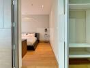 Bedroom with wooden flooring, bed, and bedside table