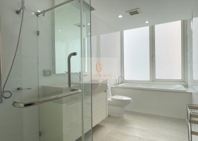 Modern bathroom with large window, bathtub, and glass shower