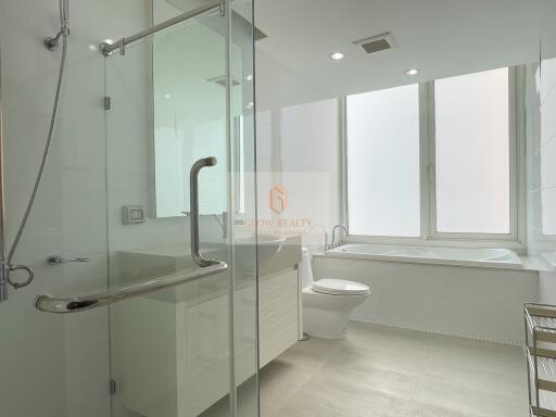 Modern bathroom with large window, bathtub, and glass shower