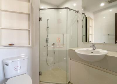 Modern bathroom with glass shower enclosure, sink, and toilet