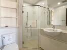 Modern bathroom with glass shower enclosure, sink, and toilet