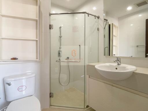 Modern bathroom with glass shower enclosure, sink, and toilet