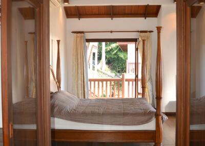 Bedroom with wooden furniture and large window