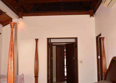 Spacious bedroom with a wooden ceiling and a four-poster bed