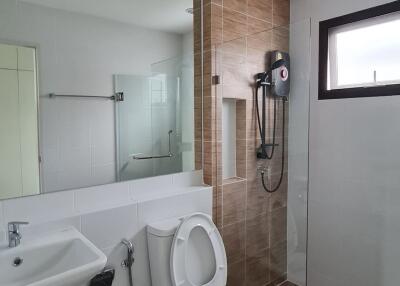Modern bathroom with glass shower partition and wall-mounted shower.