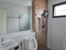 Modern bathroom with glass shower partition and wall-mounted shower.