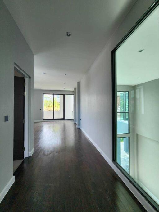 Modern hallway with wooden flooring and large windows