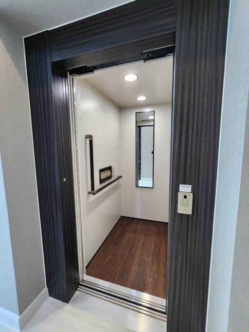 Apartment elevator interior with wooden flooring and mirror