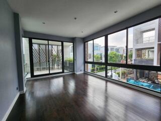 Spacious living room with large windows and wooden flooring