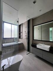 Modern bathroom with bathtub, shower, and large mirror