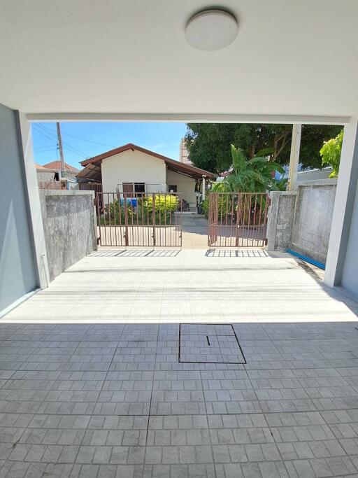 Driveway with gate and a view of neighboring house