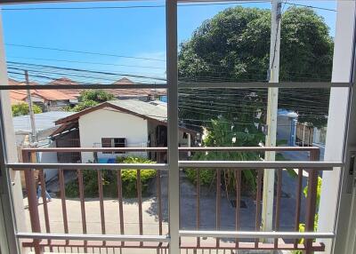 Balcony view with clear blue sky, trees, and neighborhood houses