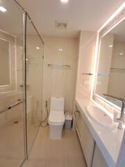 Modern bathroom with glass shower enclosure, toilet, and sink