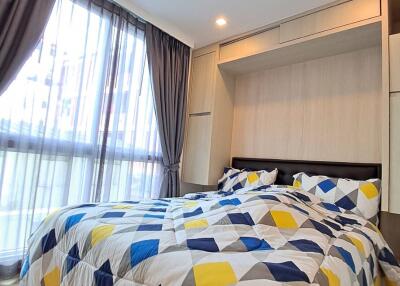 Bedroom with large window and geometric-patterned bedspread