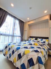 Bedroom with large window and geometric-patterned bedspread