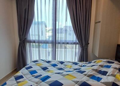 Bedroom with patterned bedding and large window