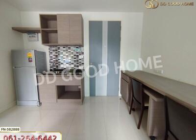 Modern kitchen with wooden cabinets, a fridge, and a dining area.