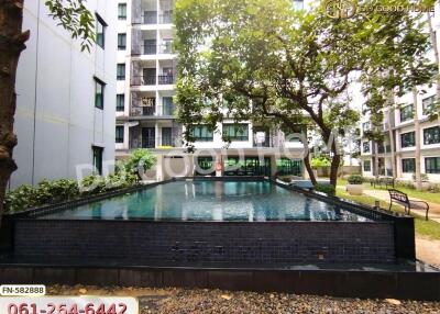 Modern apartment building with pool and lush greenery