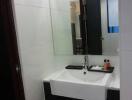 Compact modern bathroom with sink and mirror
