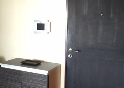 Modern entryway with dark door and minimalist cabinet