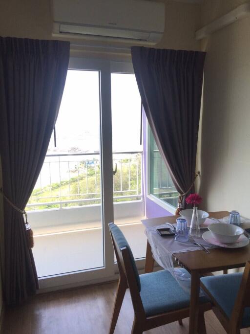 Cozy dining area with table set up near a large glass door with curtains