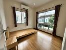 Bright and spacious bedroom with wooden floor and large windows