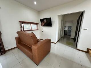 Modern living room with a wall-mounted TV and brown sofa