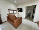 Modern living room with a wall-mounted TV and brown sofa