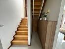 Well-lit wooden staircase with storage and decorative plants