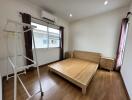 A modern minimalist bedroom with wooden furniture and large windows