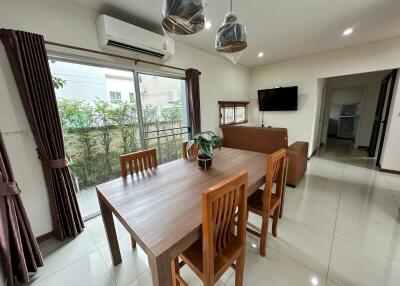 Modern living and dining area with large windows and wooden furniture