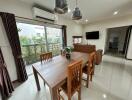 Modern living and dining area with large windows and wooden furniture