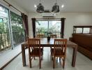 Dining room with wooden table and chairs, large windows, and air conditioning