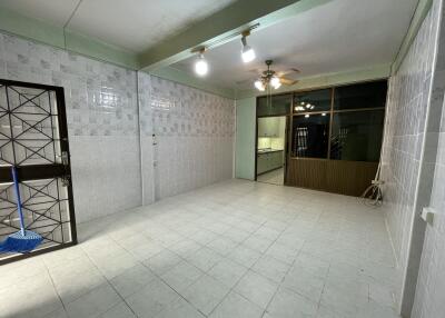 Spacious kitchen with tiled walls and ceiling fan