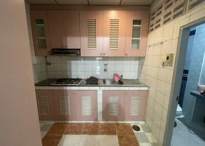 Small kitchen with pink cabinets and tiled walls