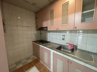 Small kitchen with pink cabinets and tiled backsplash